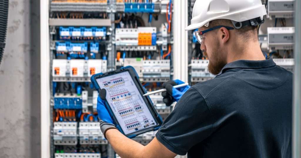An electrician doing checks on a complectation destitution board