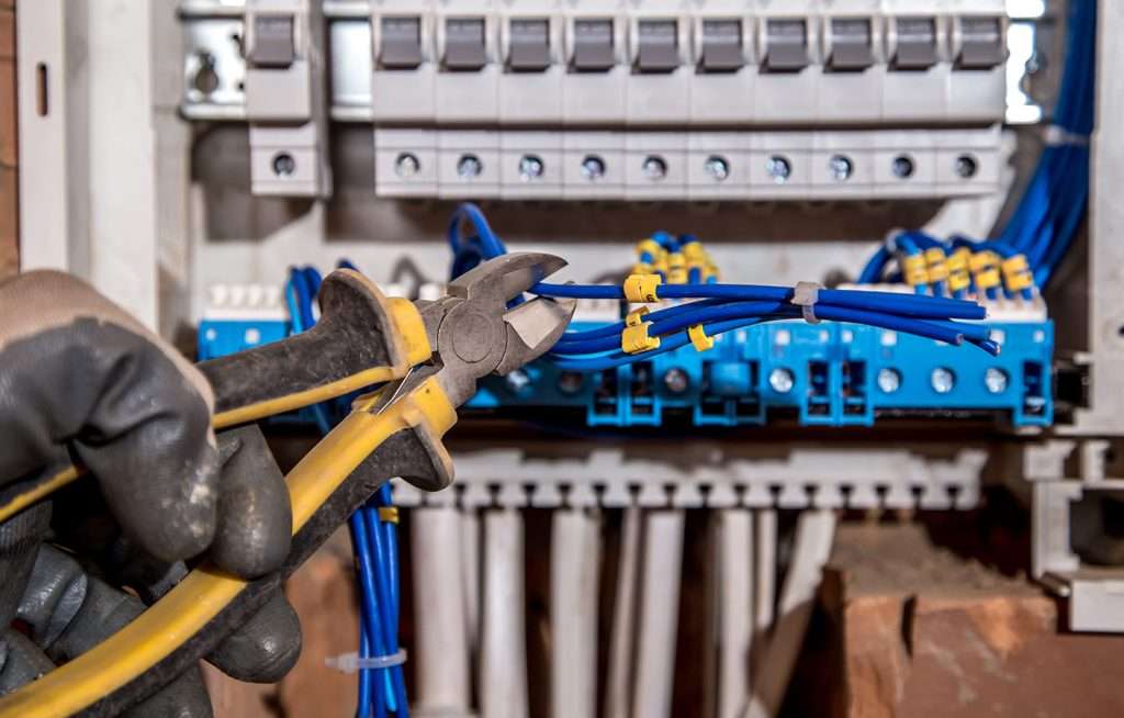 a person cutting wires with a pair of pliers