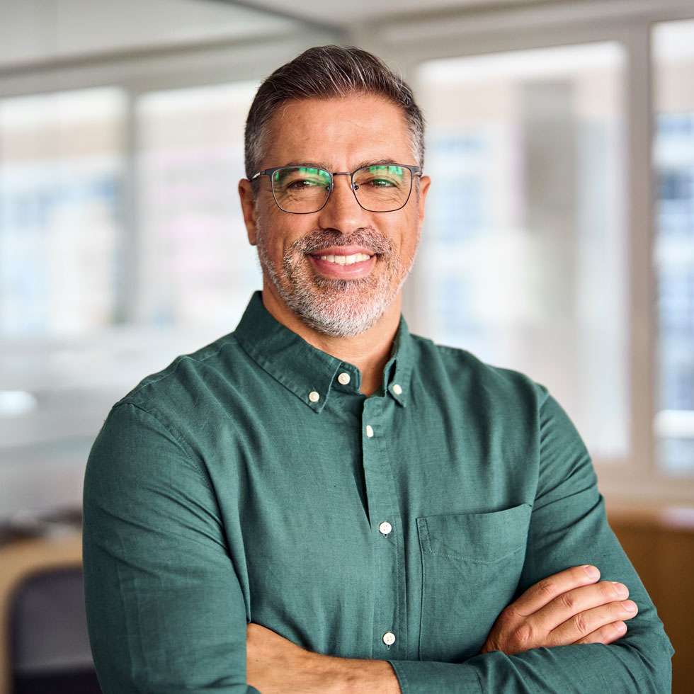 A smiling business man, standing in his open office