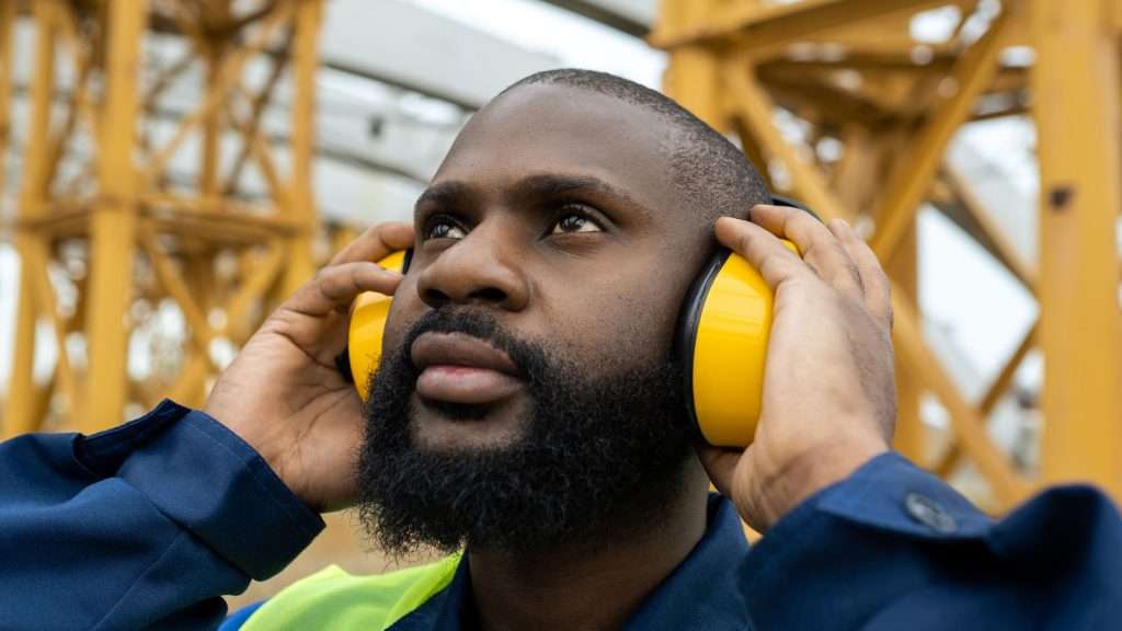 Man on site wearing protective ear guards