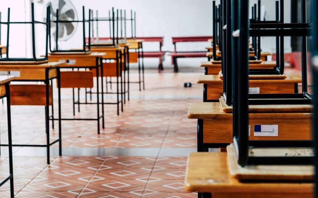 Empty school classroom. Chairs on the tables.